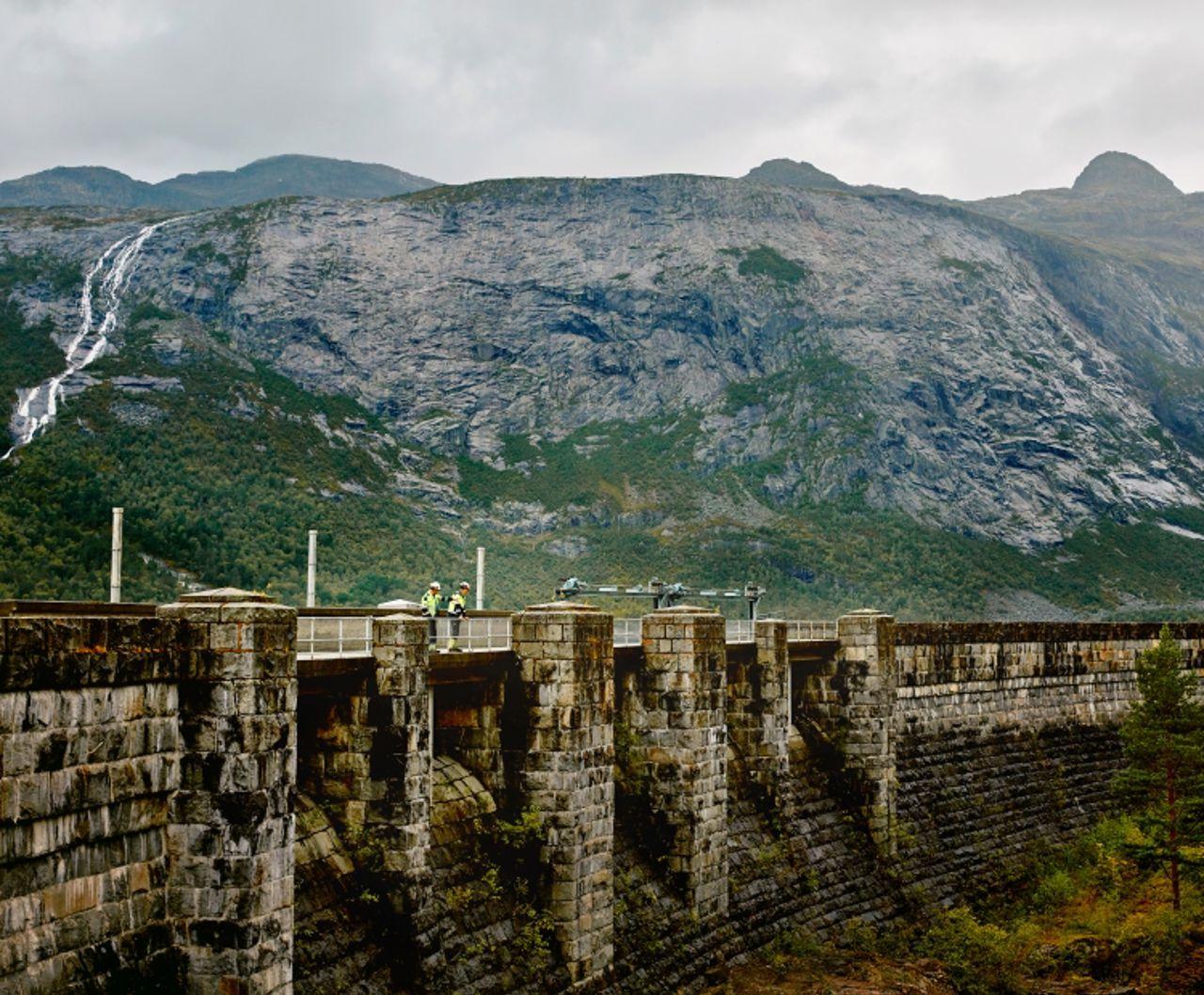 Two men standing on dam